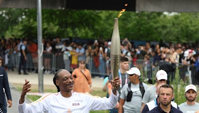 Snoop Dogg carries the Olympic torch before opening ceremony in Paris