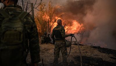 Violent wildfires slowed to 'scattered hotspots' near Athens, as hundreds of firefighters battle blazes