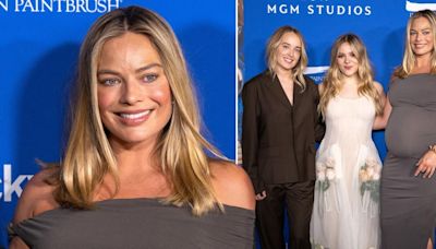 Glowing Margot Robbie embraces baby bump with snug dress on red carpet