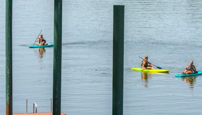 Paddleboarders enjoy warm weather as temperatures inch toward record high