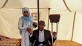 A bride and groom pose for a picture inside a tent ahead of a mass wedding ceremony in Khan Yunis, the southern Gaza Strip