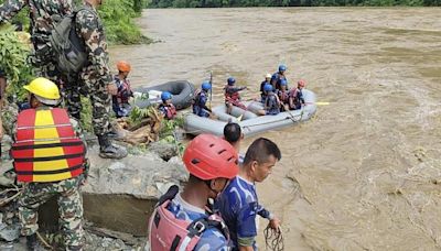 Rescuers recover first body from 2 buses that were hit by landslide and fell into a river in Nepal