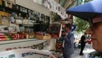 An Iranian woman looks at a newspaper headline at a stall in Tehran, the day after the runoff presidential election