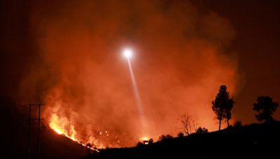 Wildfires spread devastation and smoke across U.S. West as California man defends his home