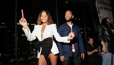 Chrissy Teigen Puts Coquette Spin on Suiting in White Blazer Featuring Statement Bow for JBL Fest 2024 With John Legend