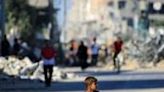 A boy carries water al-Bureij refugee camp in Gaza, where UN agencies have warned of dire shortages of vital supplies