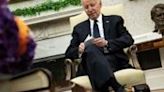 US President Joe Biden looks at note cards as he meets with Romanian President Klaus Iohannis in the Oval Office of the White House in Washington...