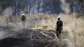 Los bomberos sofocan un incendio cerca de la vía del tren en la carretera de Encinarejo