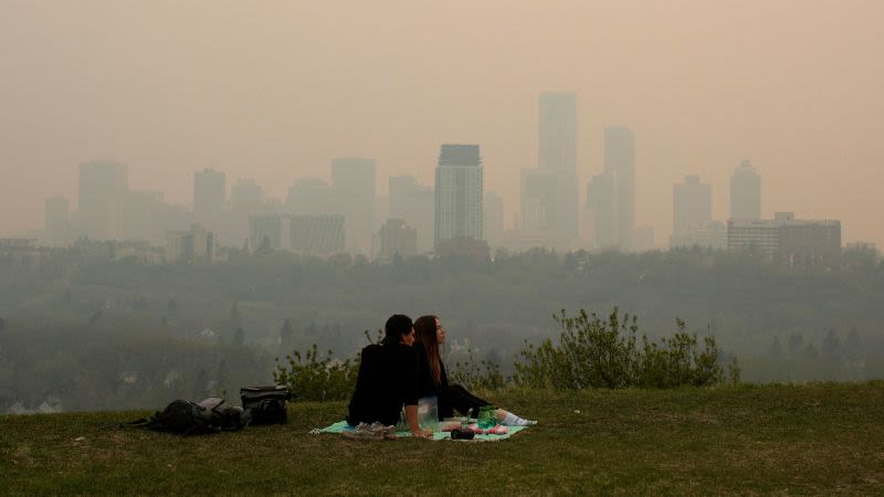 More than 100 blazes are burning in western Canada and sending smoke to the US. One of them is threatening to overrun a town