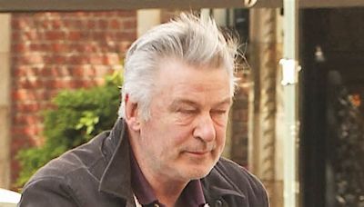 Alec Baldwin, 66, looks EXHAUSTED as he stops to lean against a railing while taking his children on a walk in NYC... as he faces charges over Rust shooting