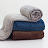 Small and lightweight blanket primarily used as a decorative accent. Can be folded or draped over furniture. Often made from cozy materials such as fleece or fur.