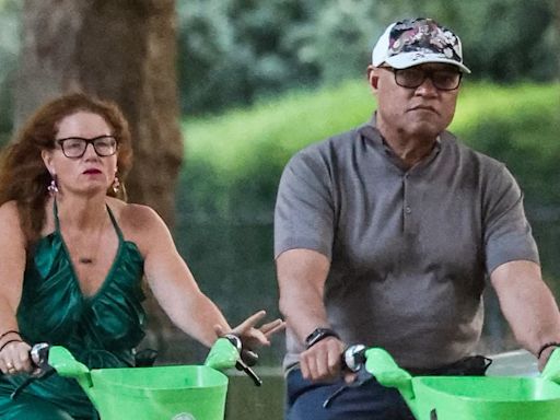 Laurence Fishburne rides an e-bike alongside mystery female companion