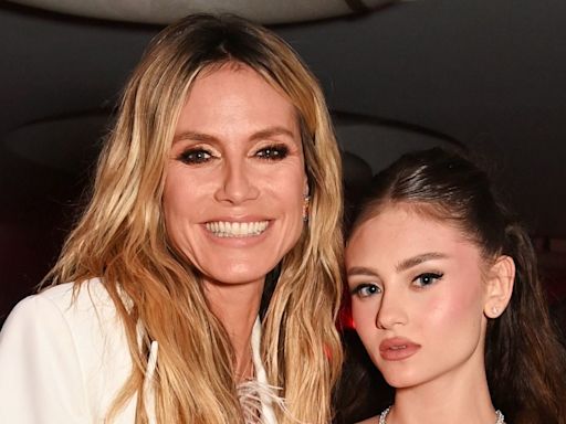 Heidi Klum highlights her very toned legs in a feathered mini dress worn by daughter Leni