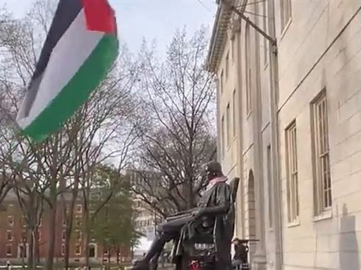 Palestinian flag is raised over Harvard statue taking the place of the Stars and Stripes that typically flies proudly above founder's memorial