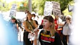 Protest against Israel occurs with backdrop of graduating UGA students taking pics at Arch