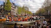 Orange crush: Boats packed with revelers tour Amsterdam canals to celebrate the king's birthday