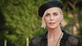 Charlize Theron Pairs Stunning Black Swimsuit With Mesh Dress