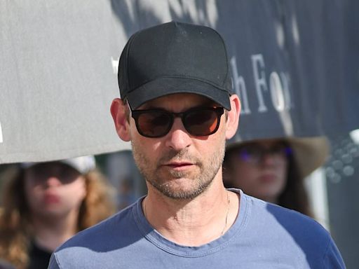 Tobey Maguire, 49, chats up a young brunette woman on French vacation