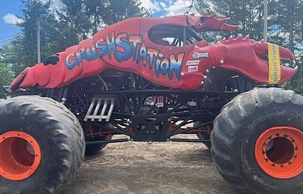 Lobster-themed monster truck clips aerial power line, toppling utility poles in spectator area