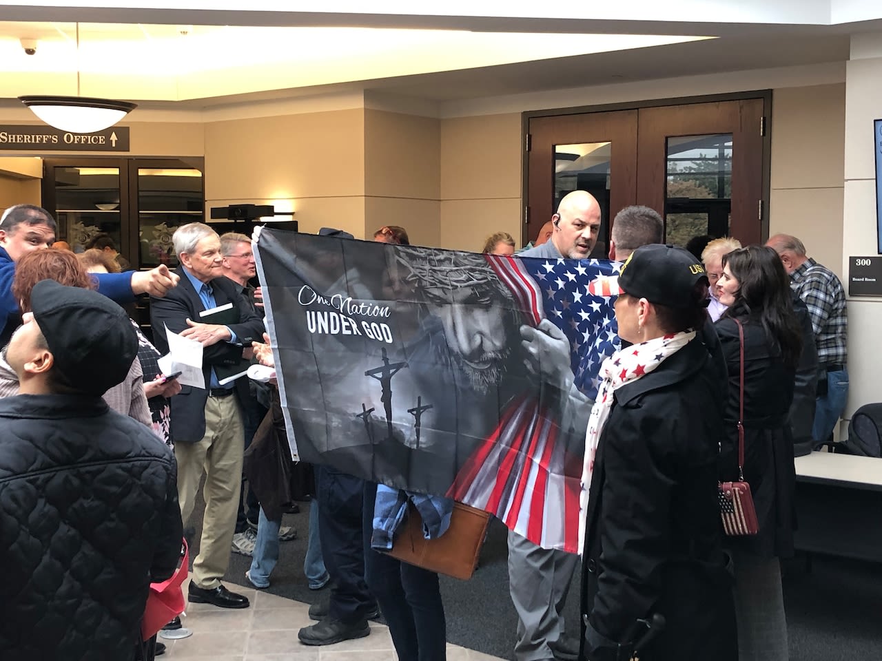 Protesters to satanic speaker at Ottawa County board pack foyer before meeting