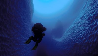 Photos show what cave divers discovered when they swam inside an iceberg the size of Jamaica. Today, it's gone.