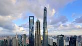 A cluster of 3 towering skyscrapers, each taller than 1,300 feet, forms a distinctive peak above Shanghai's financial district — check it out