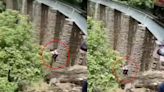 Recién casados saltan de un puente para evitar ser arrollados por un tren durante una sesión de fotos