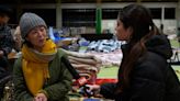 Earthquake survivors in Japan sleep in coats and hats at shelters without heat or running water