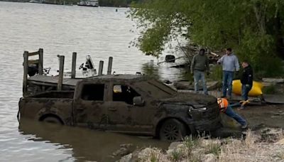 Diver recovering after two vehicles were removed from the Saginaw River in Bay City