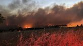 Wind-driven wildfire spreads outside a central Oregon community and prompts evacuations