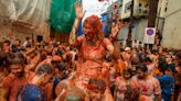 Revellers play in tomato pulp during annual food fight festival La Tomatina in Spain
