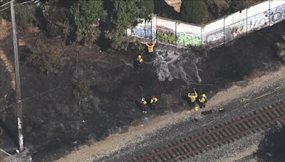 Grass fire burning by train tracks damages home in Fremont