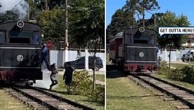 Driver saves woman posing for photo from oncoming train by kicking her off tracks