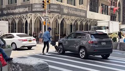 Cyclist throws bicycle in front of SUV, which runs over two-wheeler on busy street