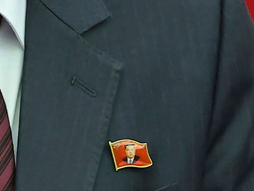 North Koreans are seen wearing Kim Jong Un pins for the first time as his personality cult grows