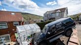 Huge 4x4 'dangles' at top of garden after rolling away from house