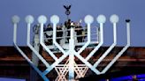 Germany's chancellor lights first Hanukkah candle on a huge menorah at Berlin's Brandenburg Gate