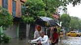 People move through a waterlogged street in India's city of Kolkata