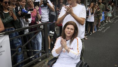 A Lebanese photojournalist, wounded in Israeli strike, carries Olympic torch to honor journalists