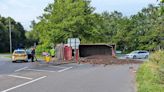 Road blocked after lorry crashes onto its side at roundabout spilling load