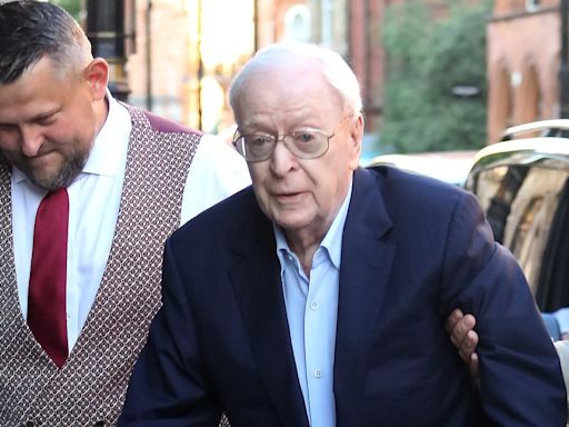 Michael Caine pushes a walker while arriving for dinner at The Ivy