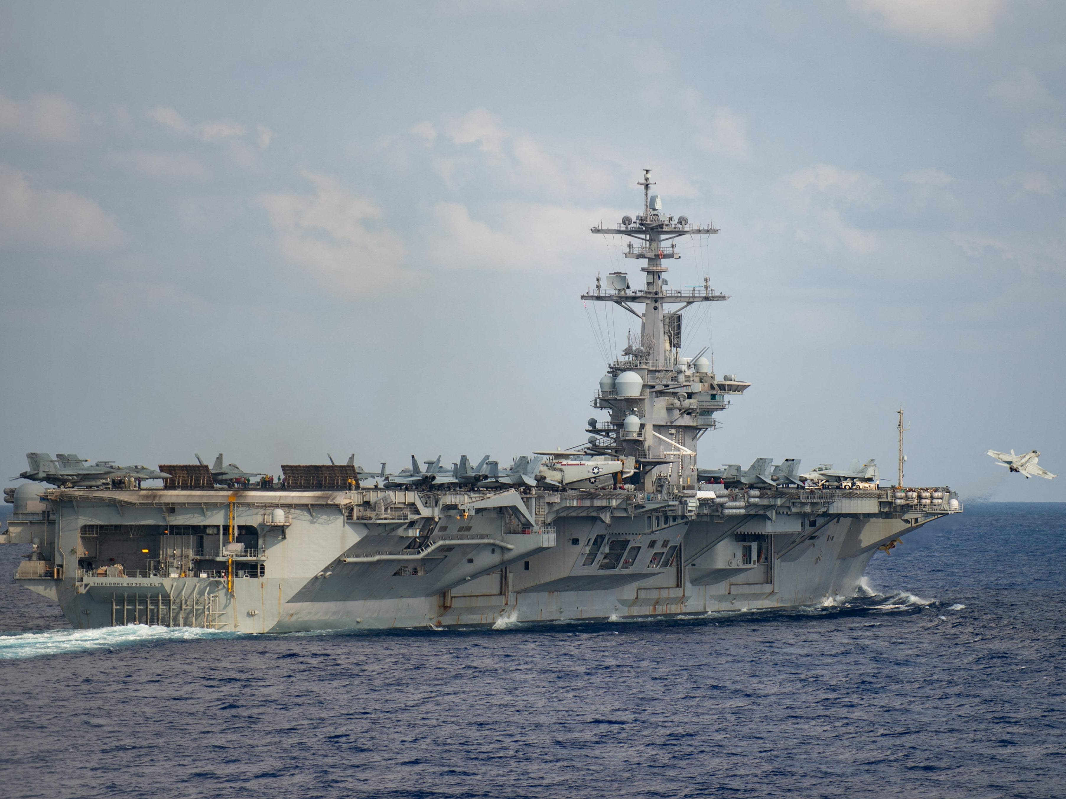 A US Navy aircraft carrier has left the Middle East, ending a rare show of force