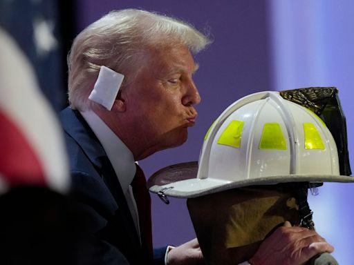RNC 2024 live: Trump kisses helmet of firefighter killed during rally shooting as he flashes $1m check in speech