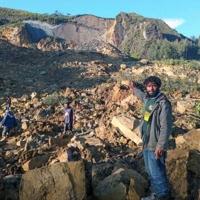 People gather at the site of a massive landslide in Papua New Guinea's Enga province