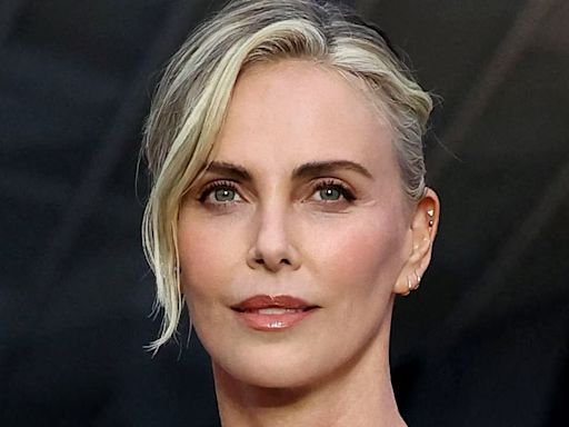 Charlize Theron stuns in chic white minidress at pre-Olympics party