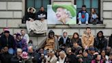 Con banderas y termos de té, grandes multitudes esperan el funeral de la reina Isabel