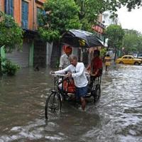 People move through a waterlogged street in India's city of Kolkata