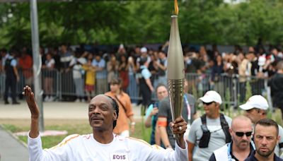 Snoop Dogg carries the Olympic torch before Opening Ceremony in Paris