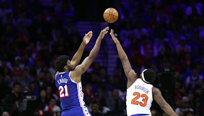 Mitchell Robinson reacts to Sixers’ Joel Embiid grabbing his leg