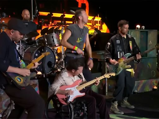 Michael J. Fox plays guitar onstage with Coldplay during their Glastonbury headline set